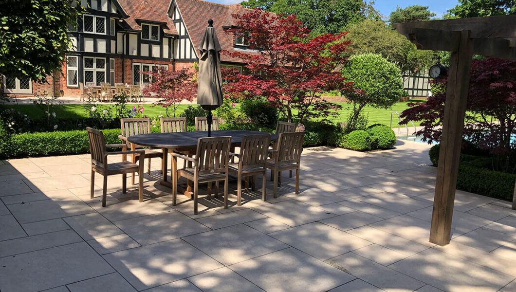 Large lawn with paved patio and seating area