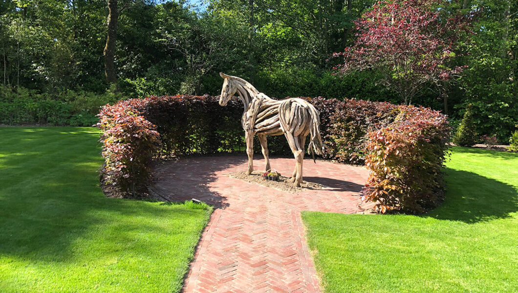 Lawn design with driftwood sculpture of horse