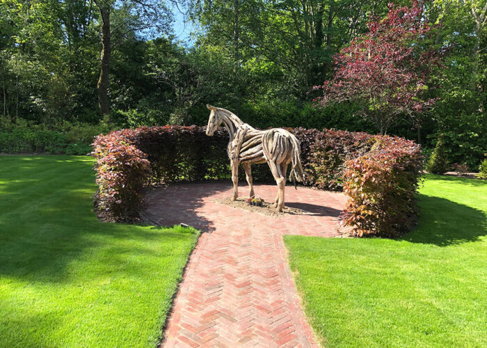 Lawn design with driftwood sculpture of horse