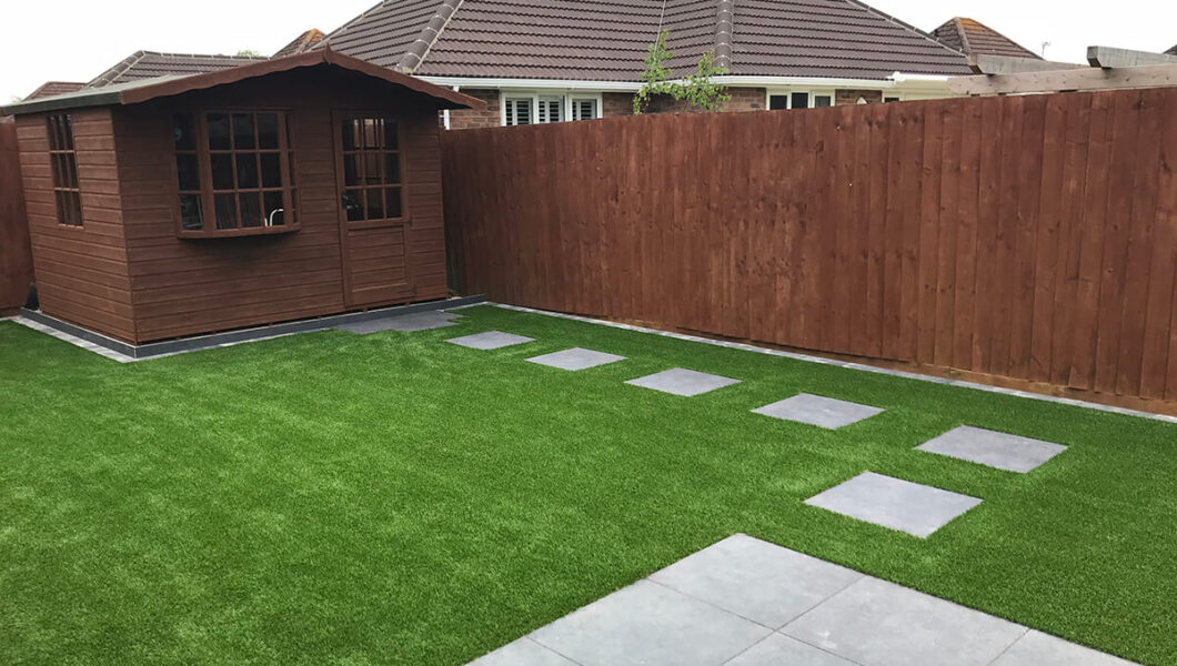 Shed in the corner of an artificial grass lawn